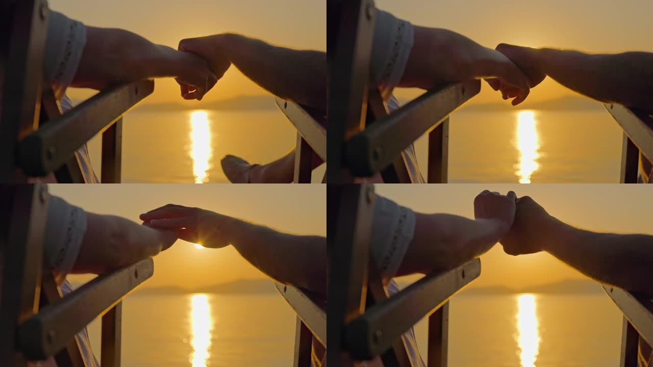 意大利厄尔巴岛日落时分一对手牵手的夫妇的景色。