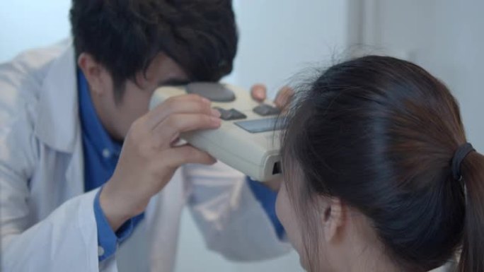 男性验光师检查女性患者的视力，特写