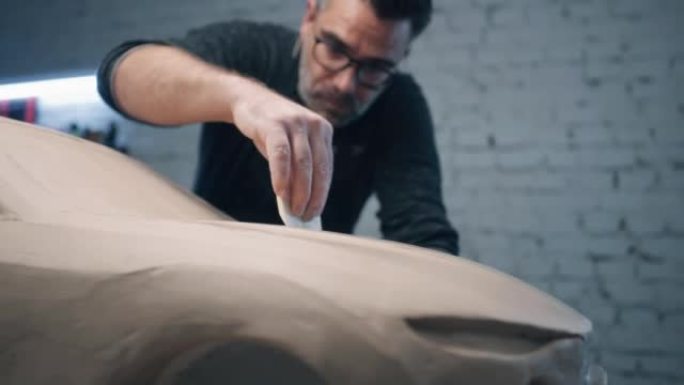 汽车设计师用雕刻工具研究汽车雕塑的设计细节