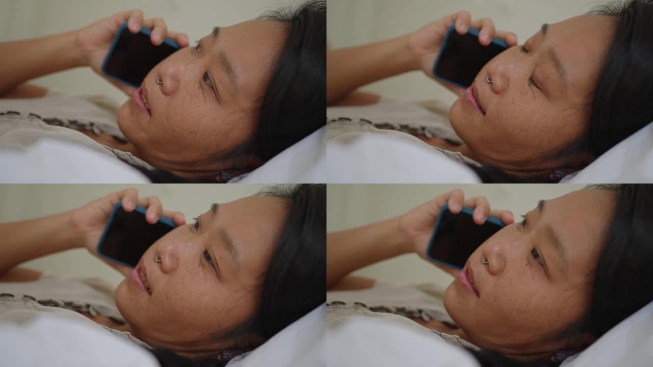 女人日本人躺在床上，一边用手机说话