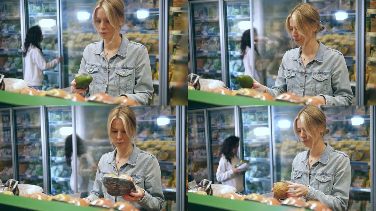 一个女人正在选择在超市买什么水果