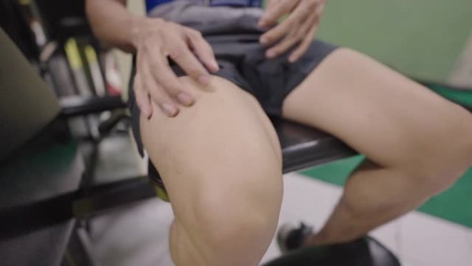 年轻人在腿部压力机上锻炼时膝盖肌肉疼痛。