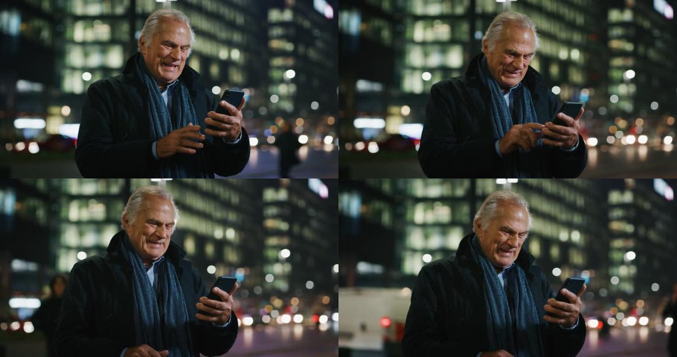 一个英俊的高级男人晚上在城市中心使用手机。