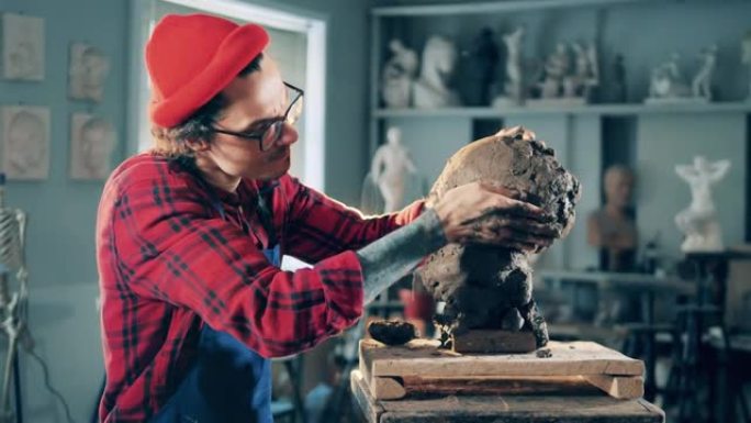 男性雕塑家正在用粘土揉捏头