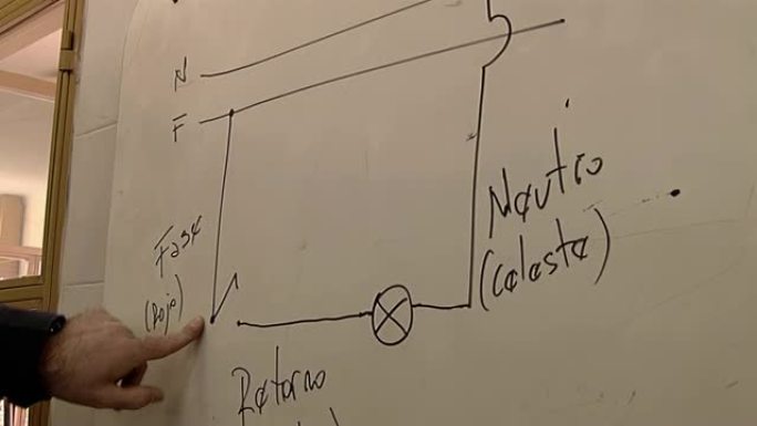 男老师在课堂上解释在白板上绘制的电气图。特写。