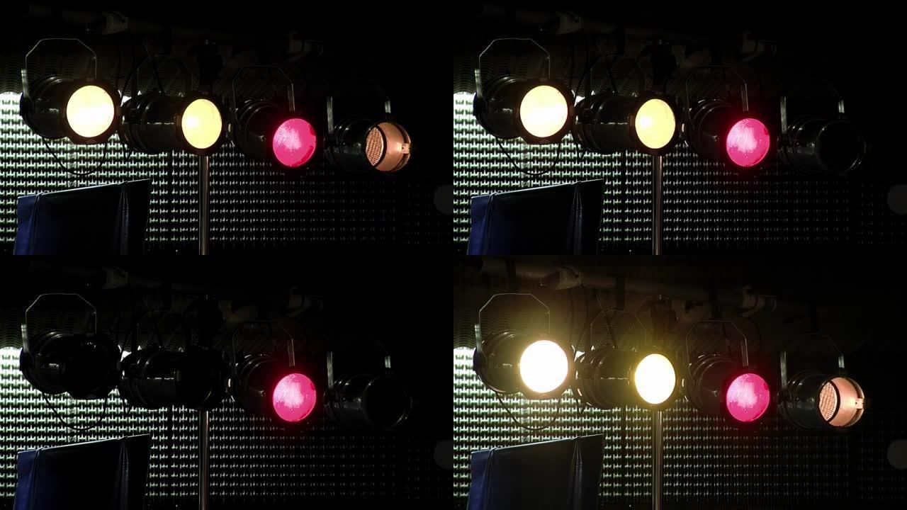 表演期间，彩色聚光灯挂在舞台上方板条上的钻机上。特写。
