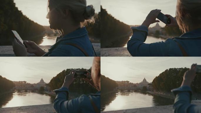 SLO MO女人在日落时使用智能手机为圣天使桥拍照