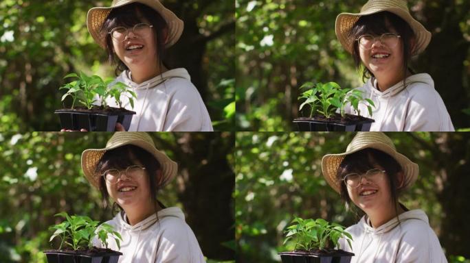 阳光明媚的亚洲女孩园艺和微笑的肖像