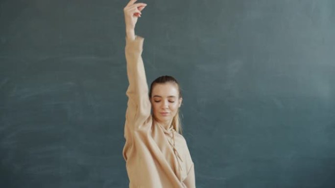 快乐女孩的肖像在现代舞工作室独自移动身体和手臂跳舞