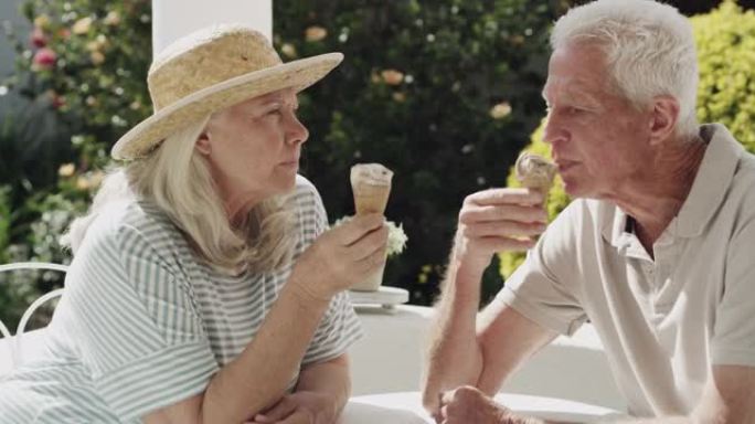 4k视频片段，一对老年夫妇坐在外面吃冰淇淋蛋筒