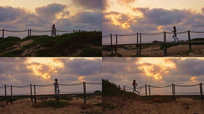 在日落期间，在海滩上的木板路上奔跑的无法识别的女运动员的跟踪慢动作镜头