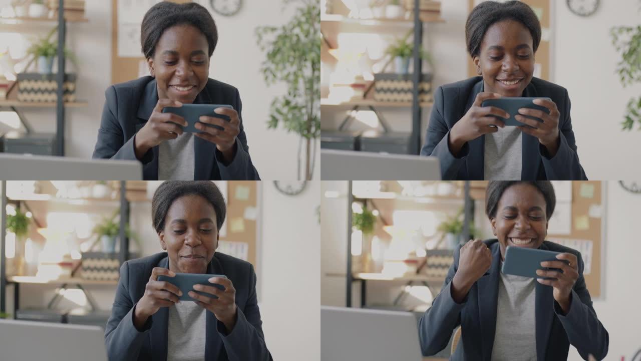快乐的非裔美国女商人玩电子游戏在工作场所休息时放松娱乐