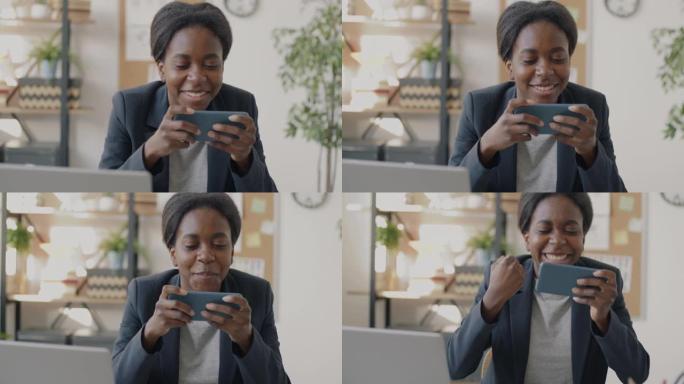 快乐的非裔美国女商人玩电子游戏在工作场所休息时放松娱乐