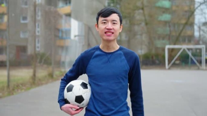 穿着运动服的微笑男子的肖像在球场上踢足球