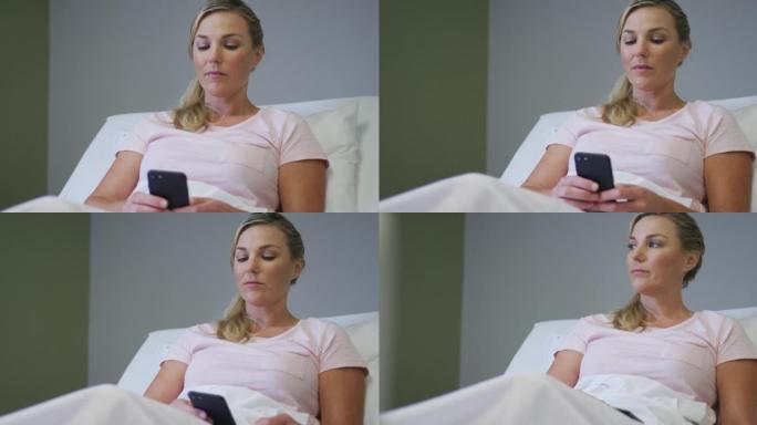 白人女性患者躺在医院的病床上并使用智能手机