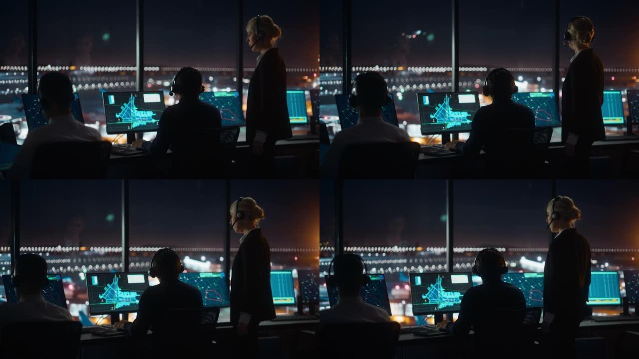 男女空中交通管制员带着耳机晚上在机场塔台交谈。办公室里满是台式电脑显示屏，配有导航屏幕，飞机飞行雷达