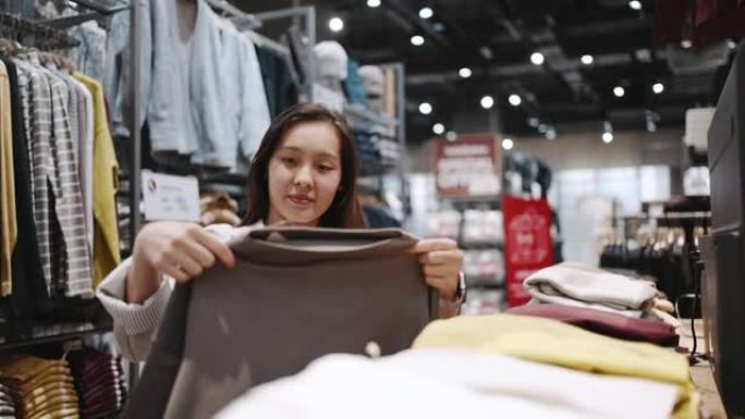 亚洲妇女在商店购买t恤
