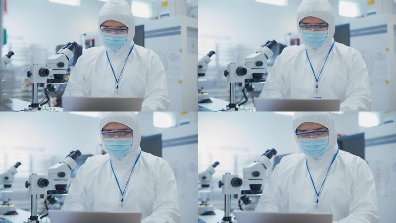 在电子制造工厂，一名身穿白色安全工作服的工程师在笔记本电脑上工作的肖像。技术员负责日常工作并插入分析