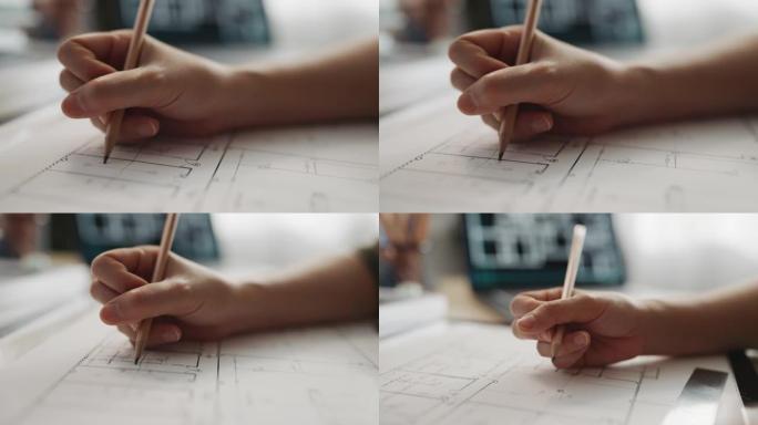 建筑师女人拿着铅笔与笔记本电脑和建筑平面图一起工作