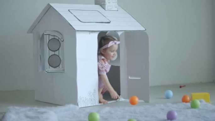 在家里玩玩具屋和塑料球的女婴，慢动作