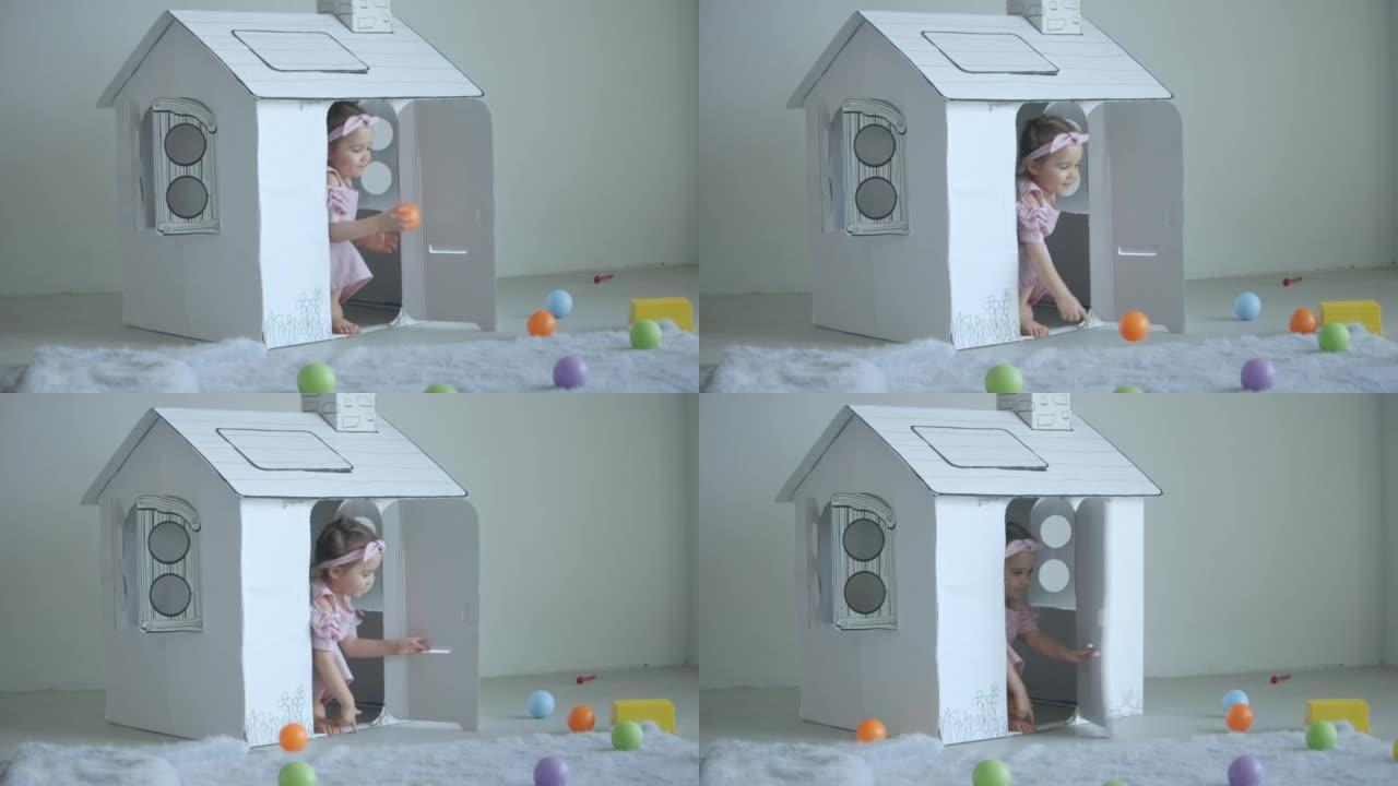 在家里玩玩具屋和塑料球的女婴，慢动作