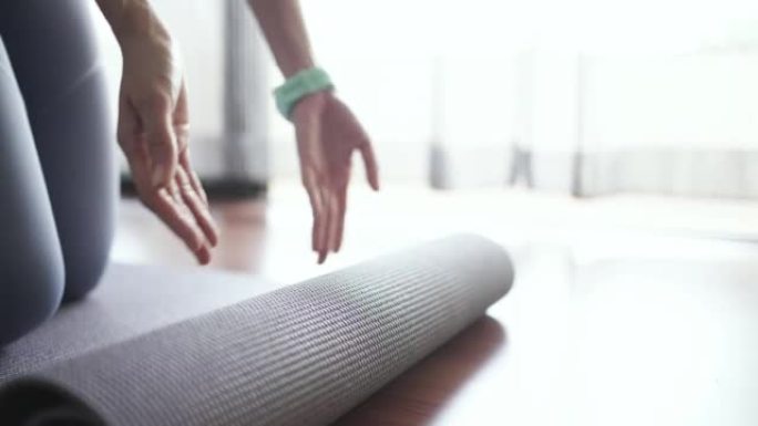 运动女人打开垫子开始在家做瑜伽锻炼