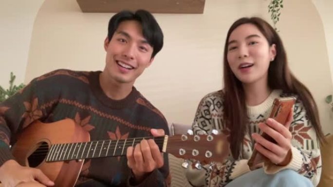 年轻人在家里弹吉他，年轻女子在社交媒体上唱歌
