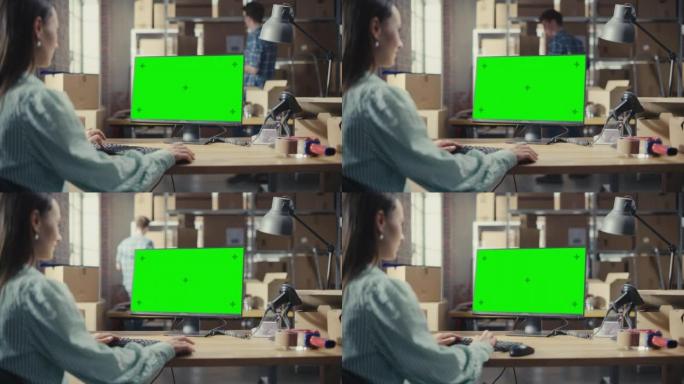 女性使用带有绿屏Chromakey模拟显示的台式计算机。销售经理和在配送仓库工作的员工用纸箱。肩膀上