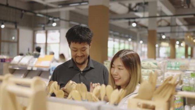 亚洲夫妇在环保零售中浏览木制厨具