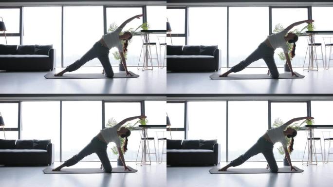 练习瑜伽女子在办公室拉升柔韧性客厅健身房