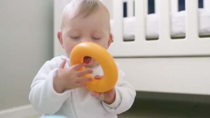4k视频片段，一个可爱的男婴在家里的地板上玩玩具