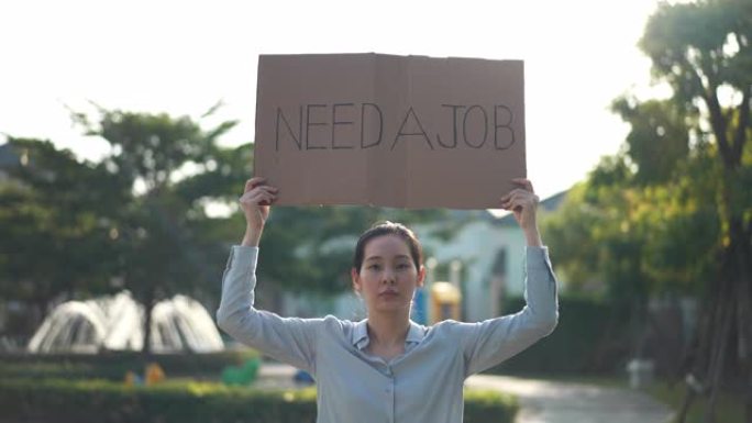 年轻的亚洲女商人举着牌子需要找工作