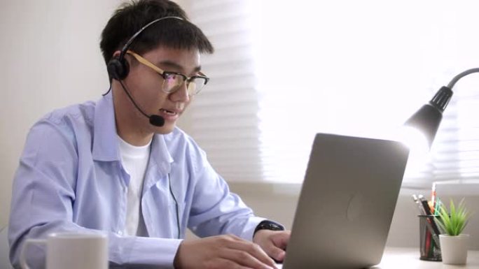 亚洲男子在家中使用笔记本电脑进行视频通话