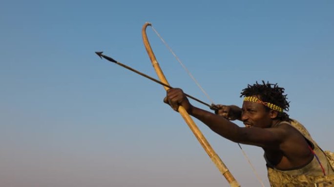 慢动作特写哈扎狩猎采集者部落成员旨在拍摄他的弓箭坦桑尼亚