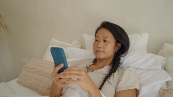 女子日裔在手机上网时躺在床上