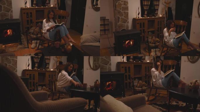 女人在家里壁炉旁的椅子上放松时看书喝茶