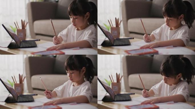 女孩在家上学时使用笔记本电脑观看在线课程
