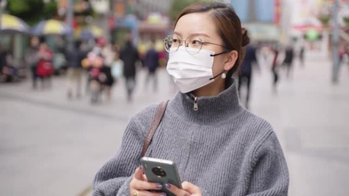 亚洲女子戴口罩行走都市