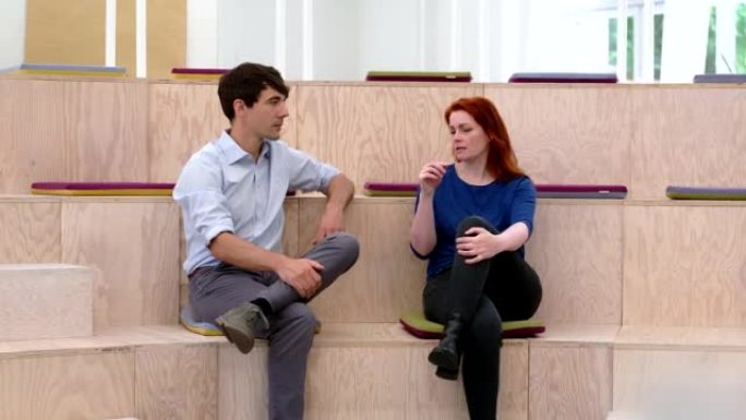 Two businesspeople sitting in office auditorium an