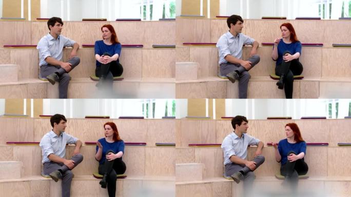 Two businesspeople sitting in office auditorium an