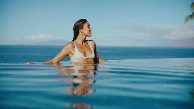 女人在豪华度假村的游泳池里放松