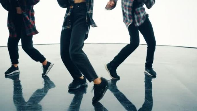 由三名年轻的专业舞者组成的多元化小组，在工作室环境中，在明亮的白色背景的大Led屏幕前近距离表演嘻哈