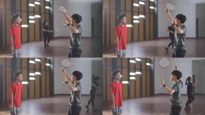 亚洲华裔女子羽毛球教练在羽毛球场教她的学生