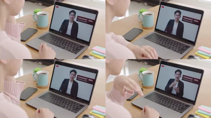 后视图年轻的亚洲女性收听虚拟商务会议网络研讨会、管理市政厅或全体人员在家检疫社交远程会议，以亚洲演讲