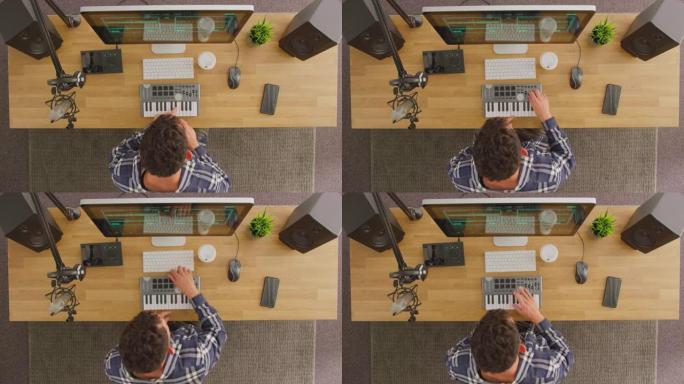 工作室中带有键盘和麦克风的工作站男性音乐家的俯视图-慢动作拍摄