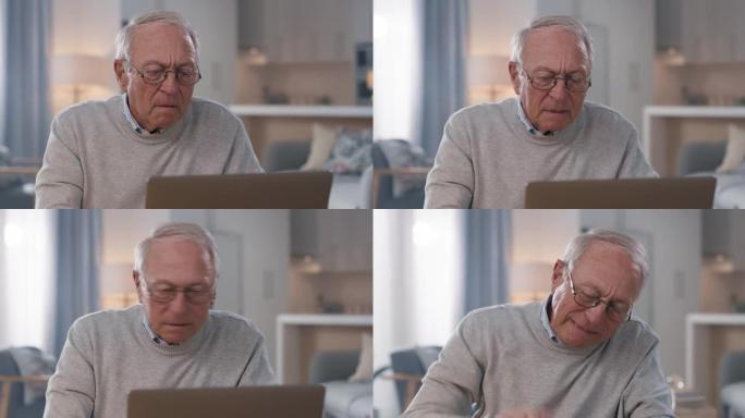 4k视频片段，一名高级男子在家中使用笔记本电脑时感到沮丧