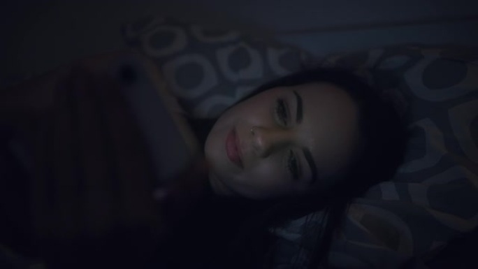女人深夜在家睡觉时使用手机