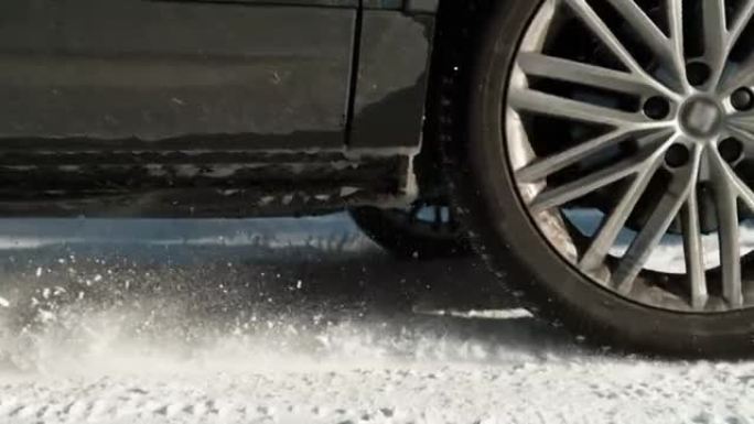 特写: 车辆的车轮在获得牵引力的同时抛出积雪。