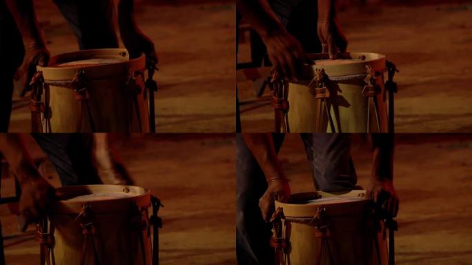 一个年轻人的手拉紧了阿根廷传统民间音乐鼓 “Bombo Leguero” 的皮带。特写。