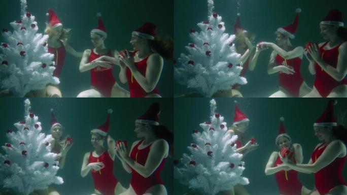 圣诞节庆祝活动的概念。身穿红色泳装的快乐微笑的年轻女子在水下慢动作交换礼物。